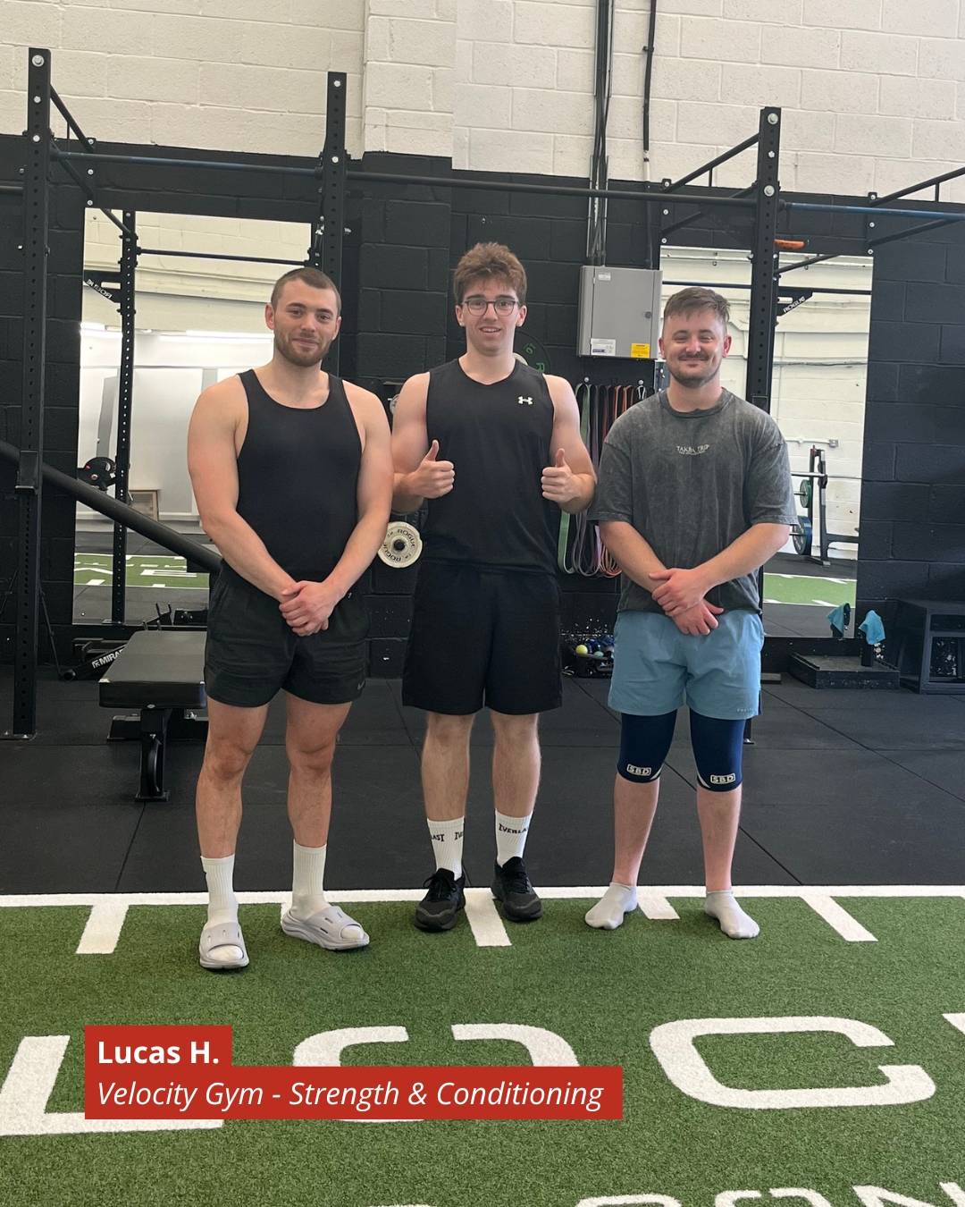 Three athletes stand side by side in a gym, posing for a photo with squat racks in the background and a red banner reading 'Lucas H. Velocity Gym - Strength & Conditioning' in the foreground.