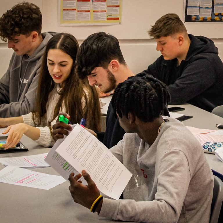 A group of students pictured in a classroom at Queen Mary's College.