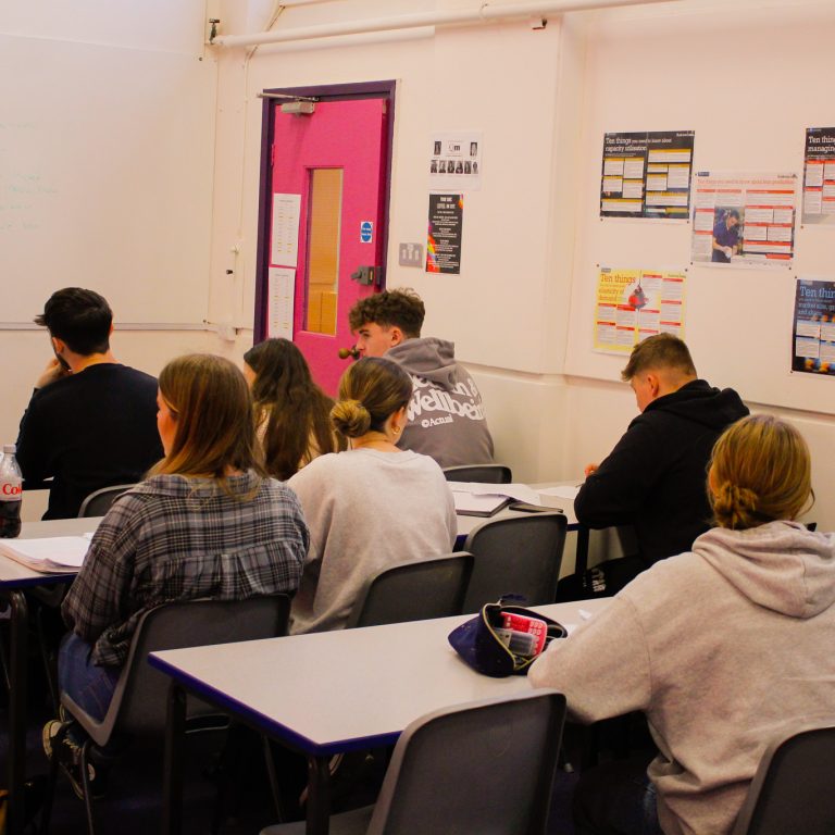 A group of students pictured in a classroom at Queen Mary's College.