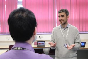 A QMC teacher discussing Politics courses at QMC with visits on Open Evening
