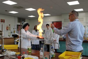 A QMC Science teacher and students showcasing an experiment in the specialist Science Labs at QMC