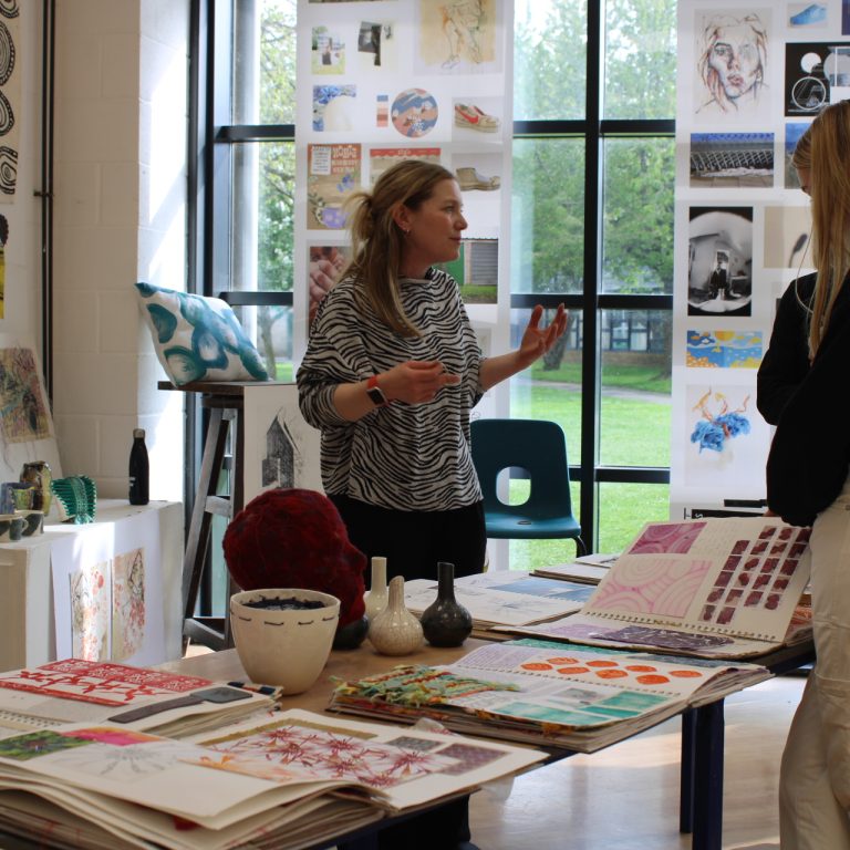 A QMC teacher discussing Art at QMC with visits on Open Evening