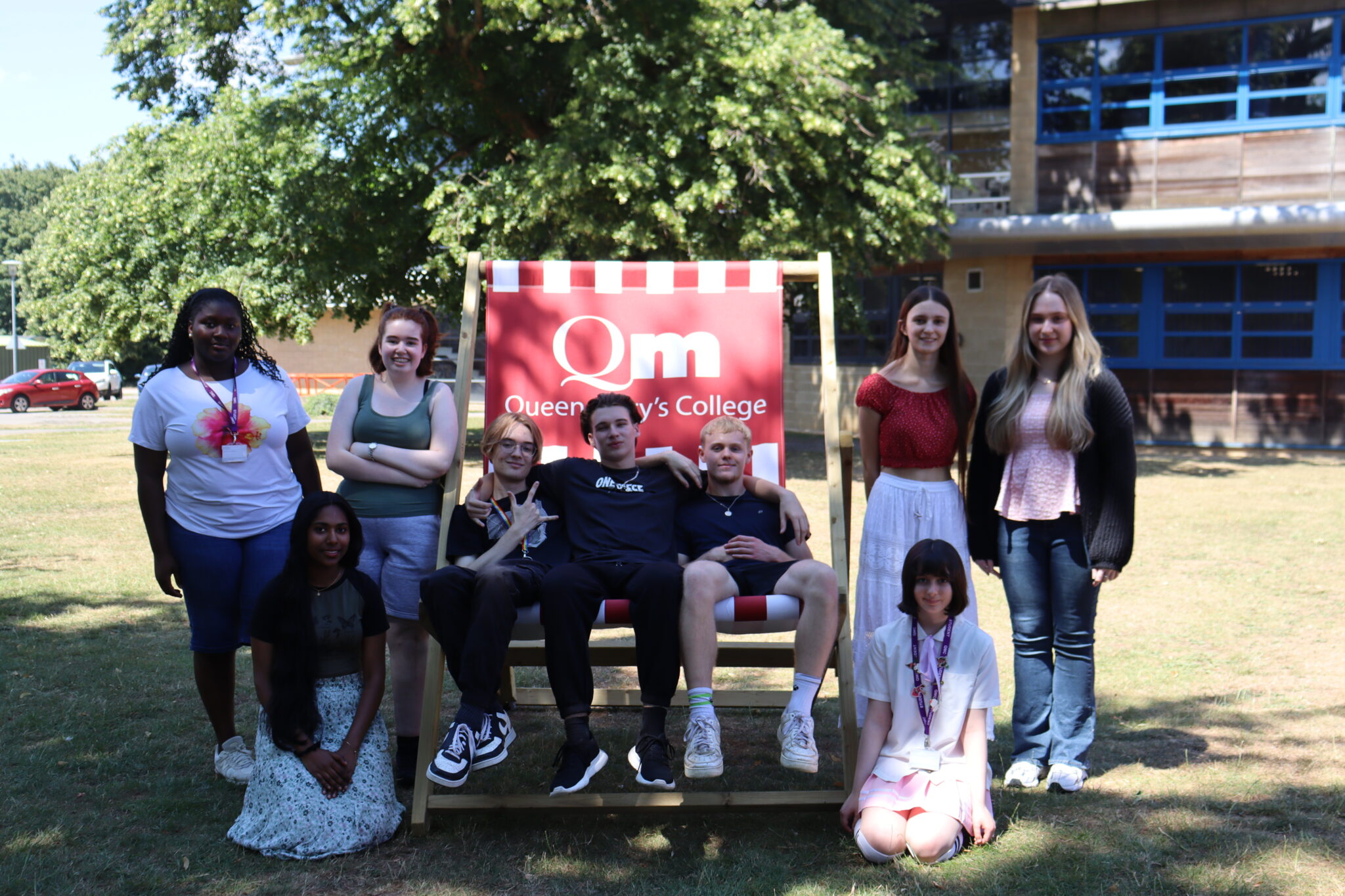a group of people posing for a photo in front of a deck chair