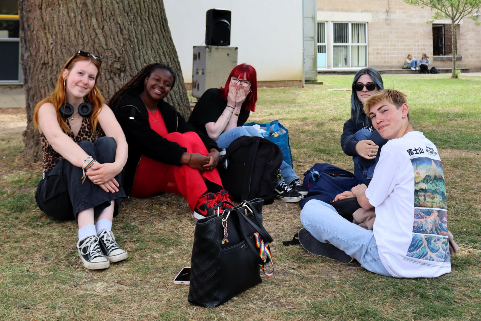 a group of people sitting under a tree