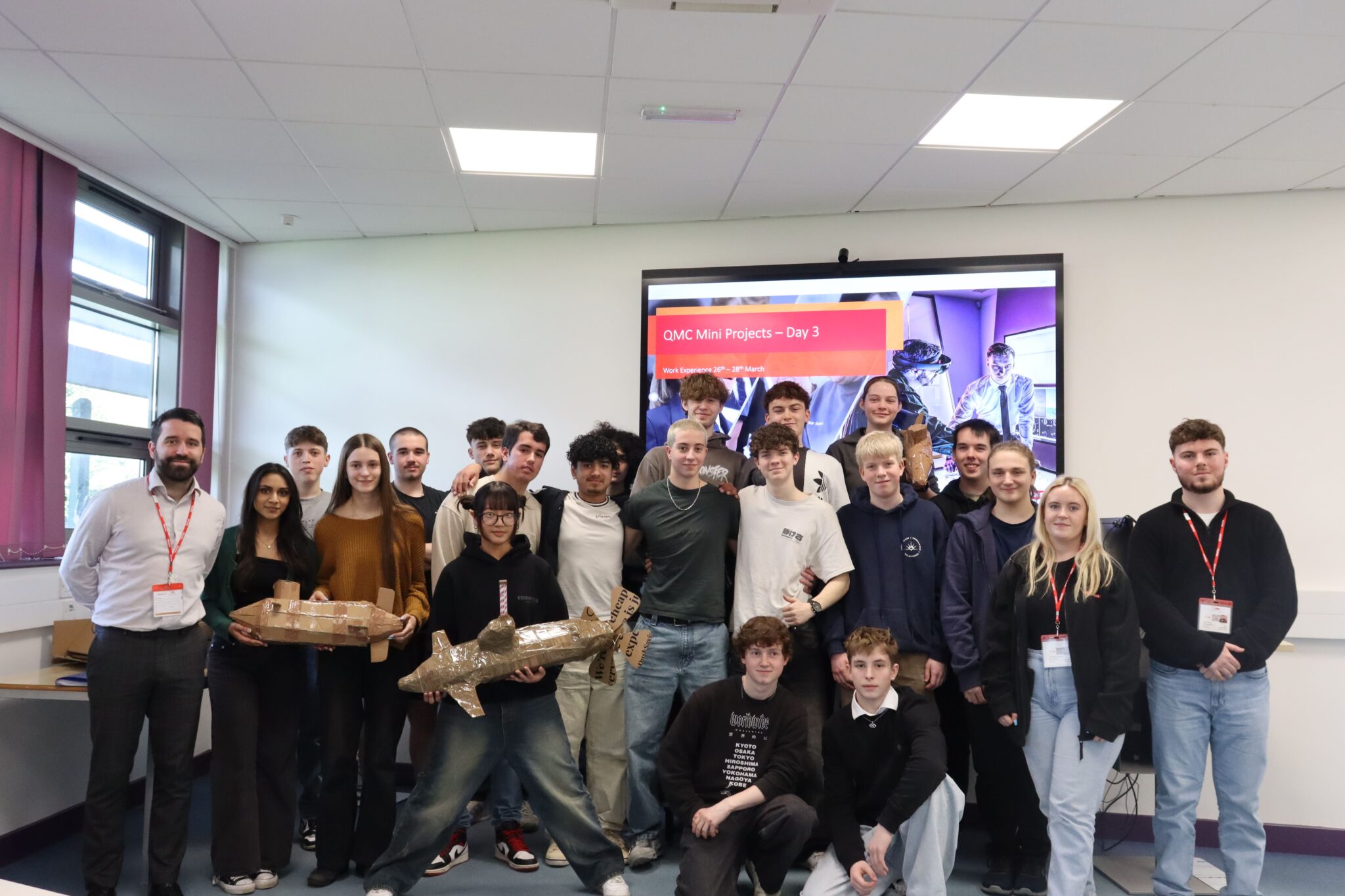 a group of people posing for a picture in front of a screen