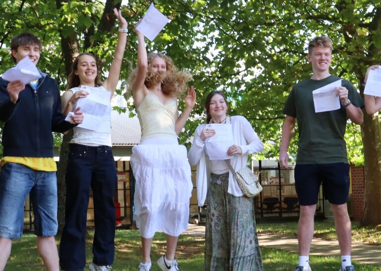 a group of people posing for a picture in front of a tree