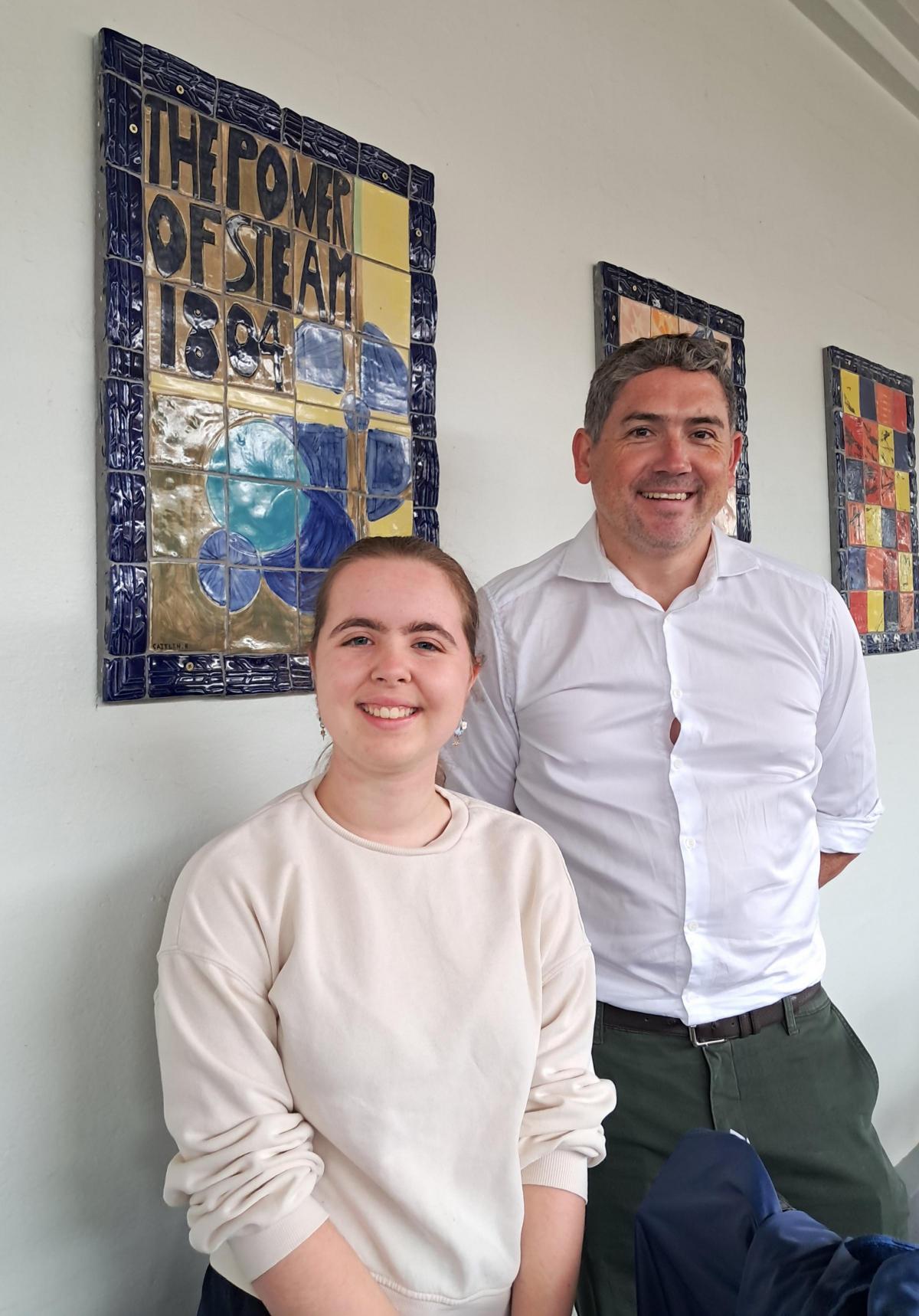 two people standing next to each other in front of art