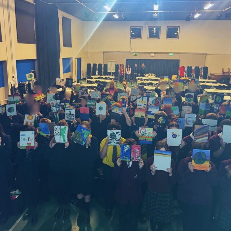 group of people standing in hall with pictures held up