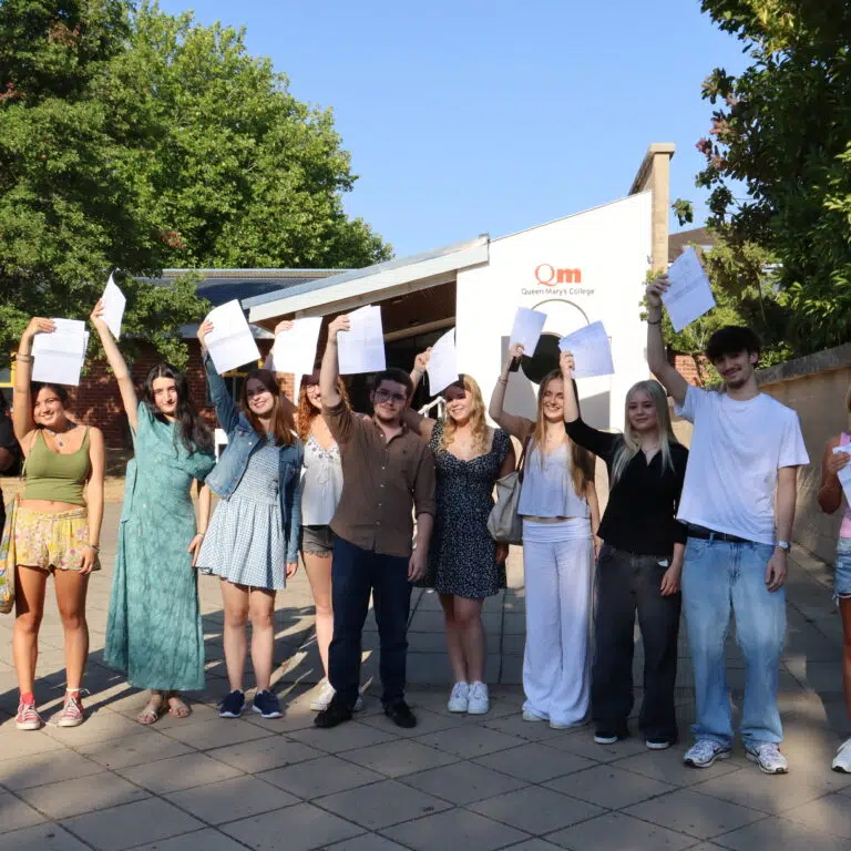 Group of diverse students celebrating A Level Results Day, in front of Queen Mary's College