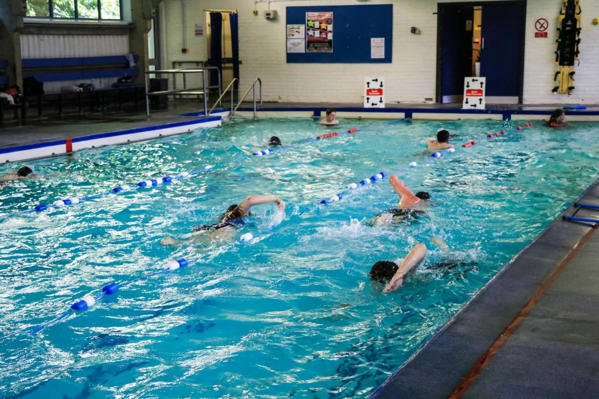 a group of people swimming in an indoor pool