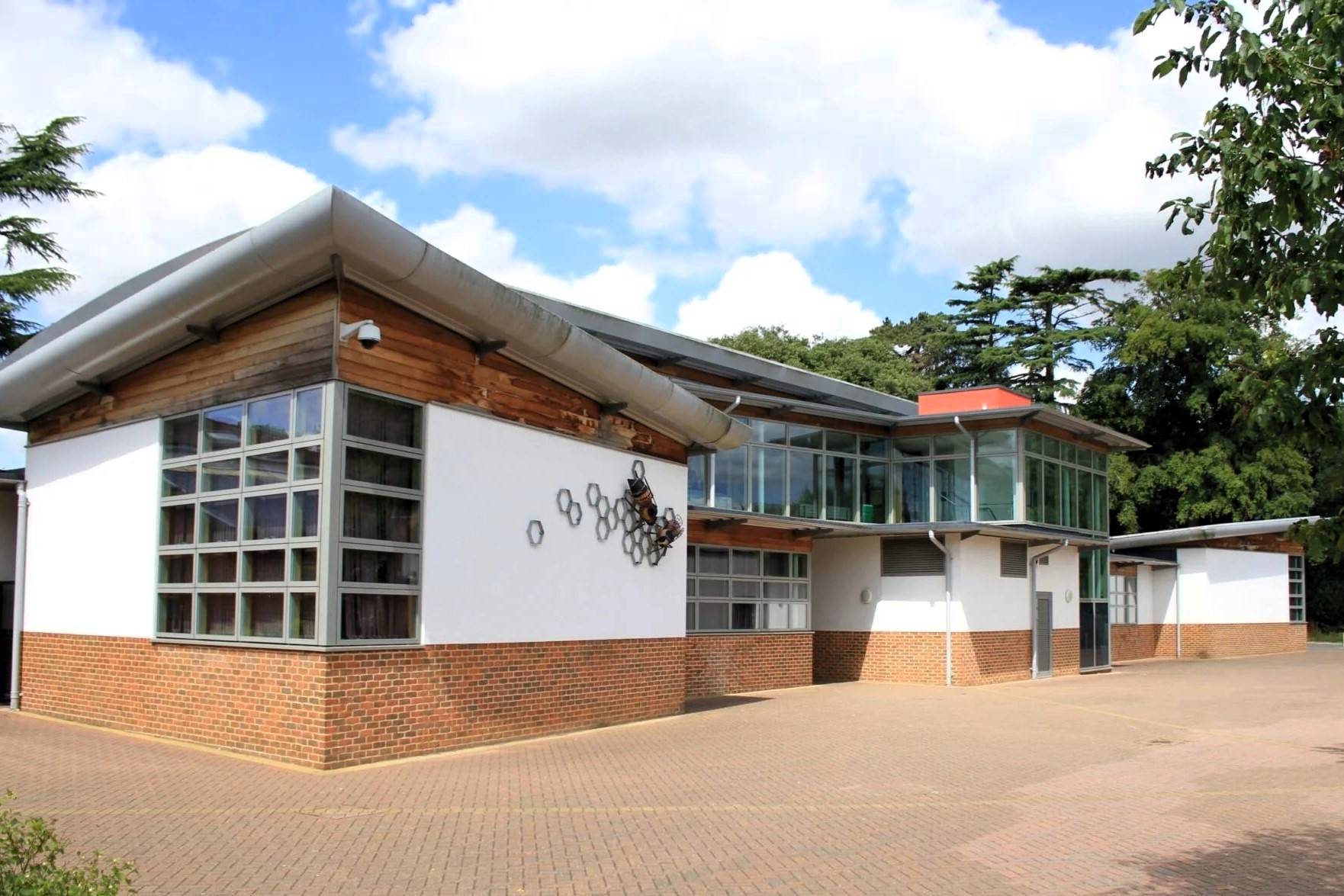 the front of a music building with trees and bushes in the background