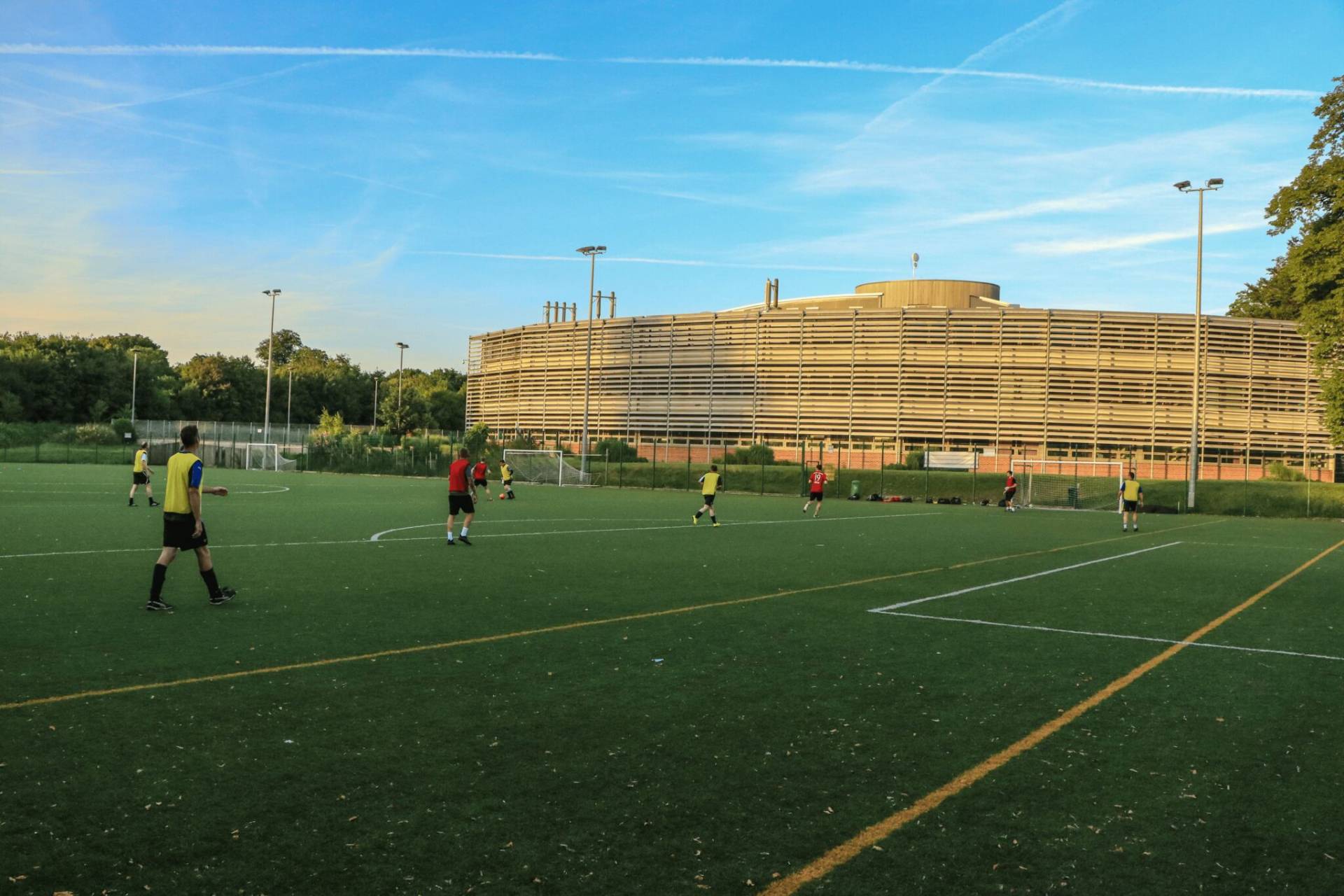 a group of people playing football in front of a building